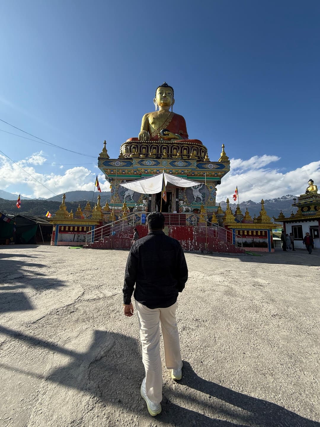 Omkar walking toward the Tawang Buddha, seen from behind